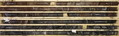 Figure 8: M24-022A (target A22) hydrothermal alteration reduction/oxidation front, transitioning from hematized quartzite to underlying heavily structured strongly graphitic pelite. (CNW Group/Fortune Bay Corp.)