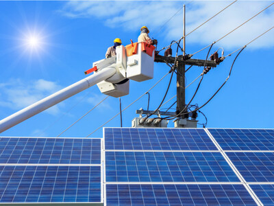 Utility crew working on power lines over solar panels