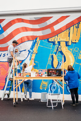 ACECO employees helping Mike Miller and Greg Didyoung install the mural