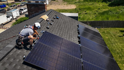 A member of the PosiGen installation team works on a rooftop solar system in Rhode Island.