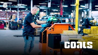 A coats employee sends Cyngn's autonomous DriveMod Tugger to its next station. The on-vehicle display is one of several ways to control the vehicle.