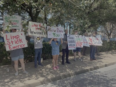 Students held signs with slogans like “Hands off my future!,” “Dr. Mann hates debate,” and “Limp Stick Energy.”