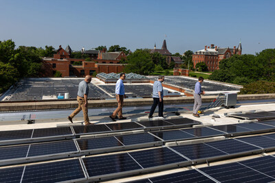 Rooftop solar panels at Gallaudet University generate power for the campus microgrid. From left to right: Scale Microgrids’ Justin Nieves, Urban Ingenuity’s (an affiliate of Working Power) Bracken Hendricks and Shalom Flank, and Gallaudet University’s Dave Good, who worked on the project, survey the results. (Photo Credit: The Pew Charitable Trusts).