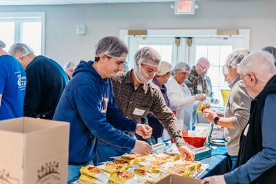 ACECO employees in an assembly line packaging food for Helping Harvest ACECO employees in an assembly line packaging food for Helping Harvest