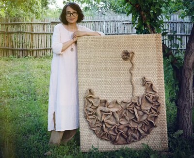 Zhang Jing and her work: a lotus pod growing from a pond of lotus flowers. Photo provided by the interviewee.