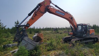 Figure 2: Backhoe collecting spodumene pegmatite mineralized boulders immediately down-ice of the principal CV5 outcrop (adjacent to the southwest side of the CV5 Pegmatite). (CNW Group/PMET Resources Inc.)