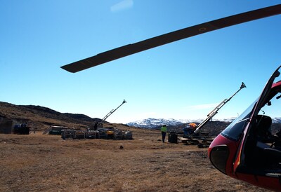 Drill rigs and logistics at Sarfartoq: View across the ST1 plateau showing the two stored diamond drill rigs, field equipment and the Air Greenland helicopter used during the May 28, 2026 site visit, illustrating the quality of existing drilling and logistics infrastructure at Sarfartoq. Drill rigs and logistics at Sarfartoq: View across the ST1 plateau showing the two stored diamond drill rigs, field equipment and the Air Greenland helicopter used during the May 28, 2026 site visit, illustrating the quality of existing drilling and logistics infrastructure at Sarfartoq.